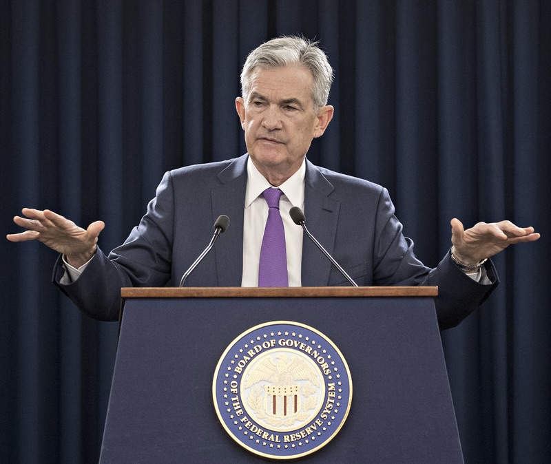 Jerome Powell at the podium, hands out